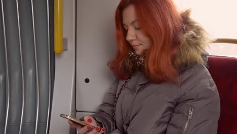mensajes de texto femeninos en el teléfono inteligente en el transporte público