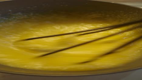 close up of a whisk mixing egg yolks in a bowl