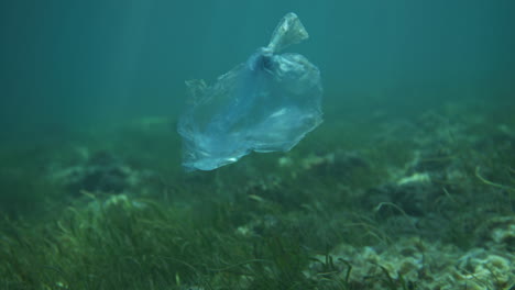 Bolsa-De-Plástico-Flotando-Bajo-El-Agua-Con-Reflejos-De-Luz.