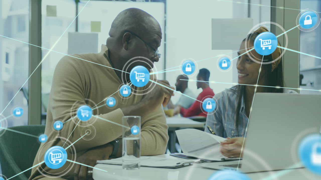 Animation of icons connected with lines over diverse coworkers discussing reports on laptop