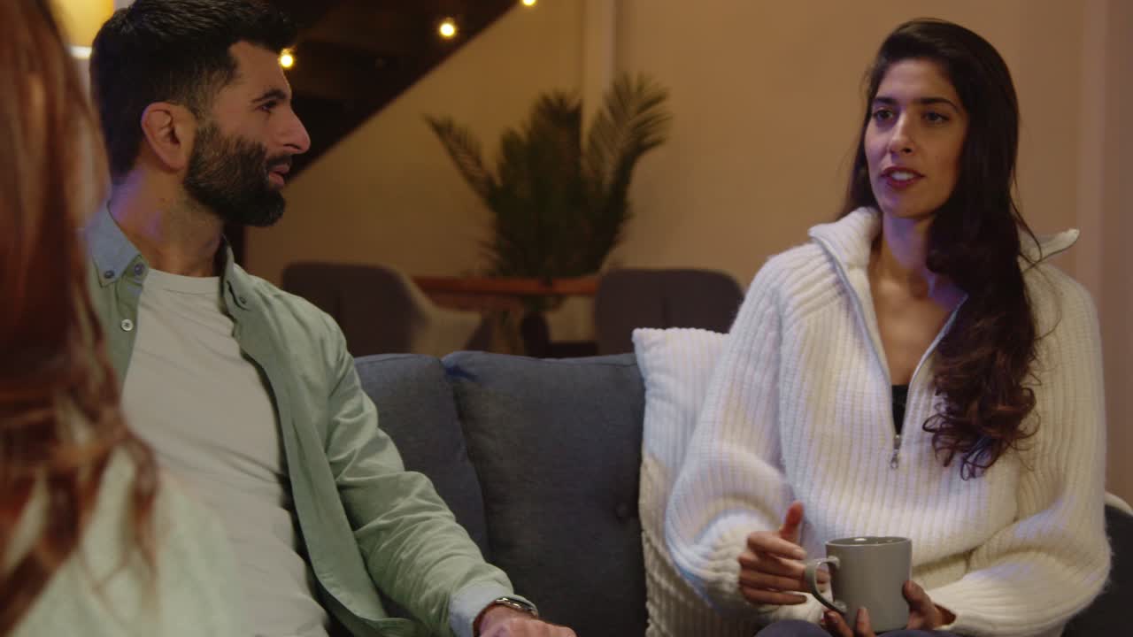 grupo de amigos relajados sentados en el sofá en casa o en un bar o cafetería hablando y bebiendo café juntos 11