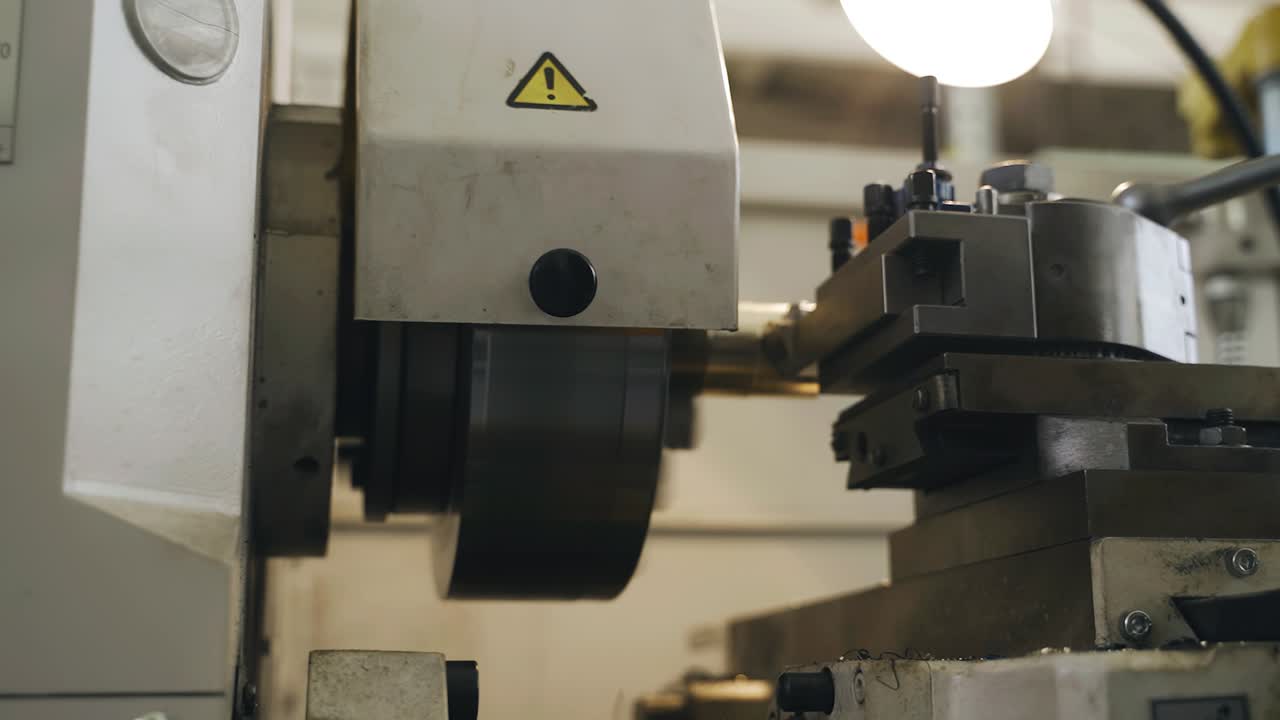 la parte se procesa en un torno en la fábrica. el cortador y las virutas metálicas de la parte son visibles