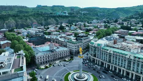 drone filmado para la plaza de la libertad en tbilisi, georgia, por la tarde antes de la puesta del sol al final de la primavera y el comienzo del verano cuando los árboles se ven verdes