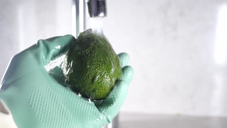 washing an avocado under tap water