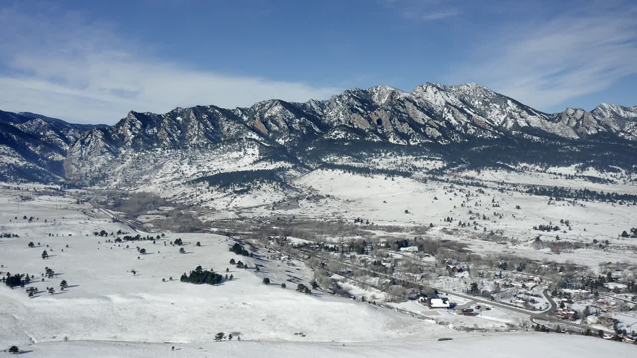 Vista aérea alejándose de las montañas en Boulder, Colorado, en un día de invierno nevado.