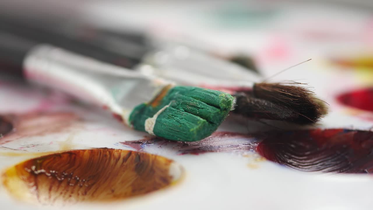 Primo piano di pennelli e tavolozza dell'artista con colori