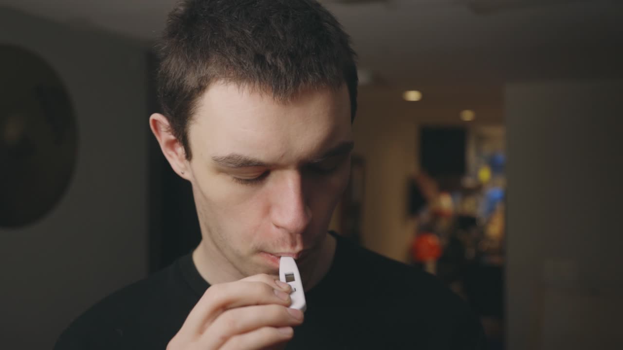 아픈 사람이 입에 온도계를 넣습니다 - 중간 샷