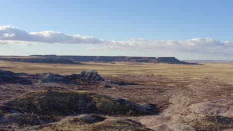 drone flying slowly over a dusty badland on a sunny day