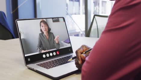 Animation-of-african-american-man-having-video-call-on-laptop