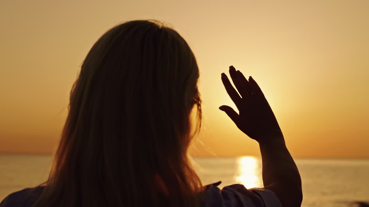 Woman watching sunset over the sea