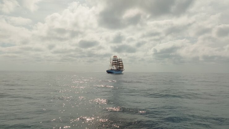 Forward drone shot of retro ship sailing on Atlantischer Ocean under cloudy day.