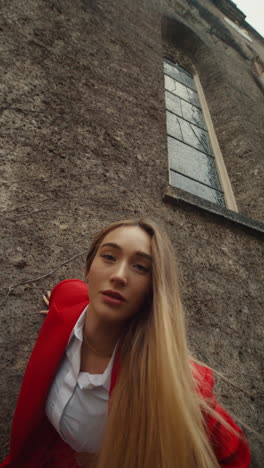 stylish woman in red suit in front of a building