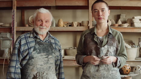 portrait of senior potter and young apprentice in workshop