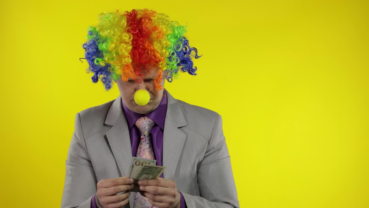 el payaso empresario empresario cuenta el dinero los ingresos. la mano roba dinero al hombre