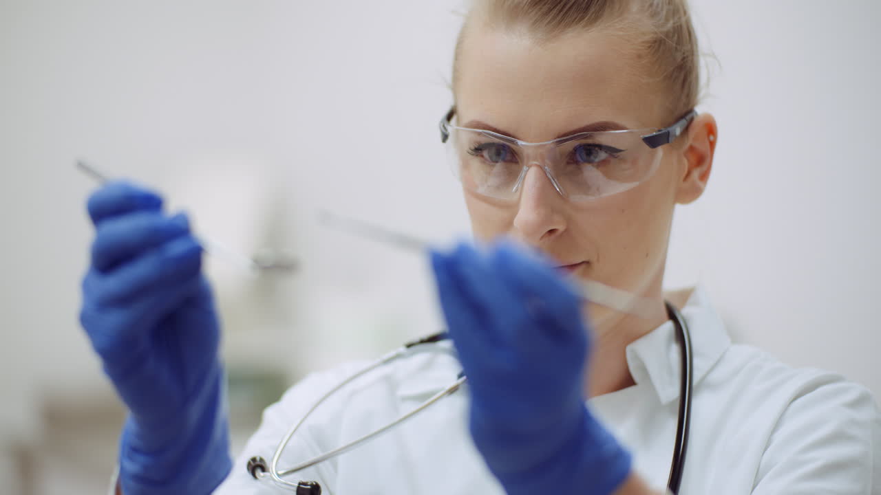 Female Dentist Checking Dental Instruments At Dental Clinic