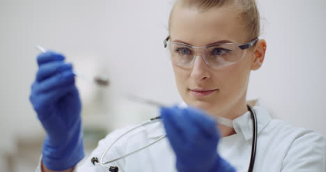 female dentist checking dental instruments at dental clinic