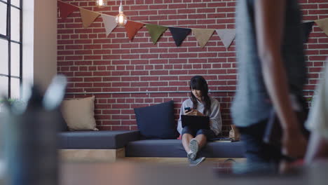 young asian business woman using laptop computer student working on project studying checking messages on smartphone enjoying relaxed office workplace listening to music