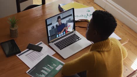 African-american-woman-using-laptop-on-video-call-with-female-colleague-working-from-home