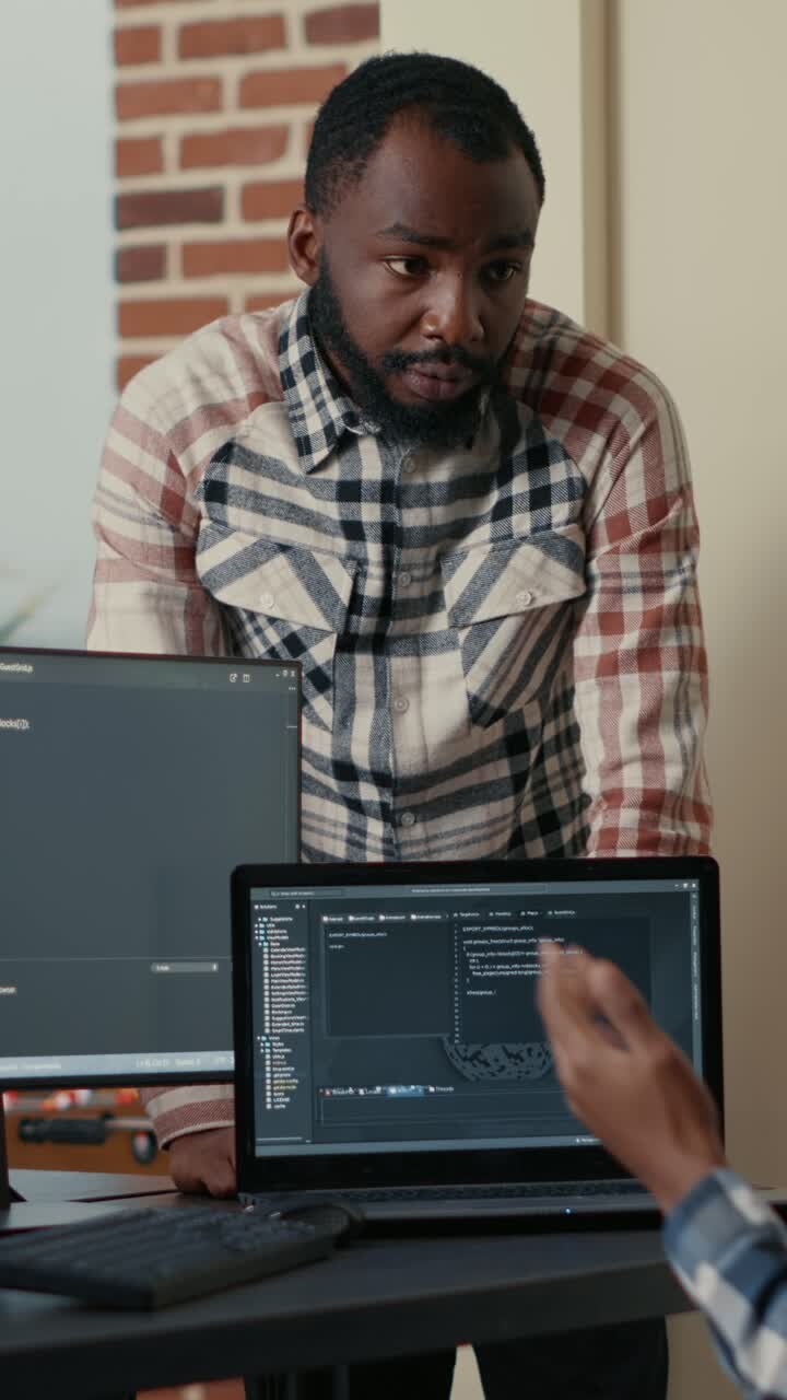 Two developers collaborating on a coding project in the office