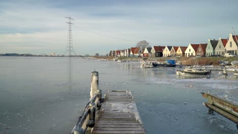 traditionelles niederländisches dorf durgerdam im seltenen weißen winter, gefrorener teich, boote und holzhäuser im hintergrund, amsterdam, niederlande