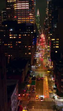 beautiful multi-colorful lights of new york. long road street going between the skyscrapers. metropolis at night. vertical video