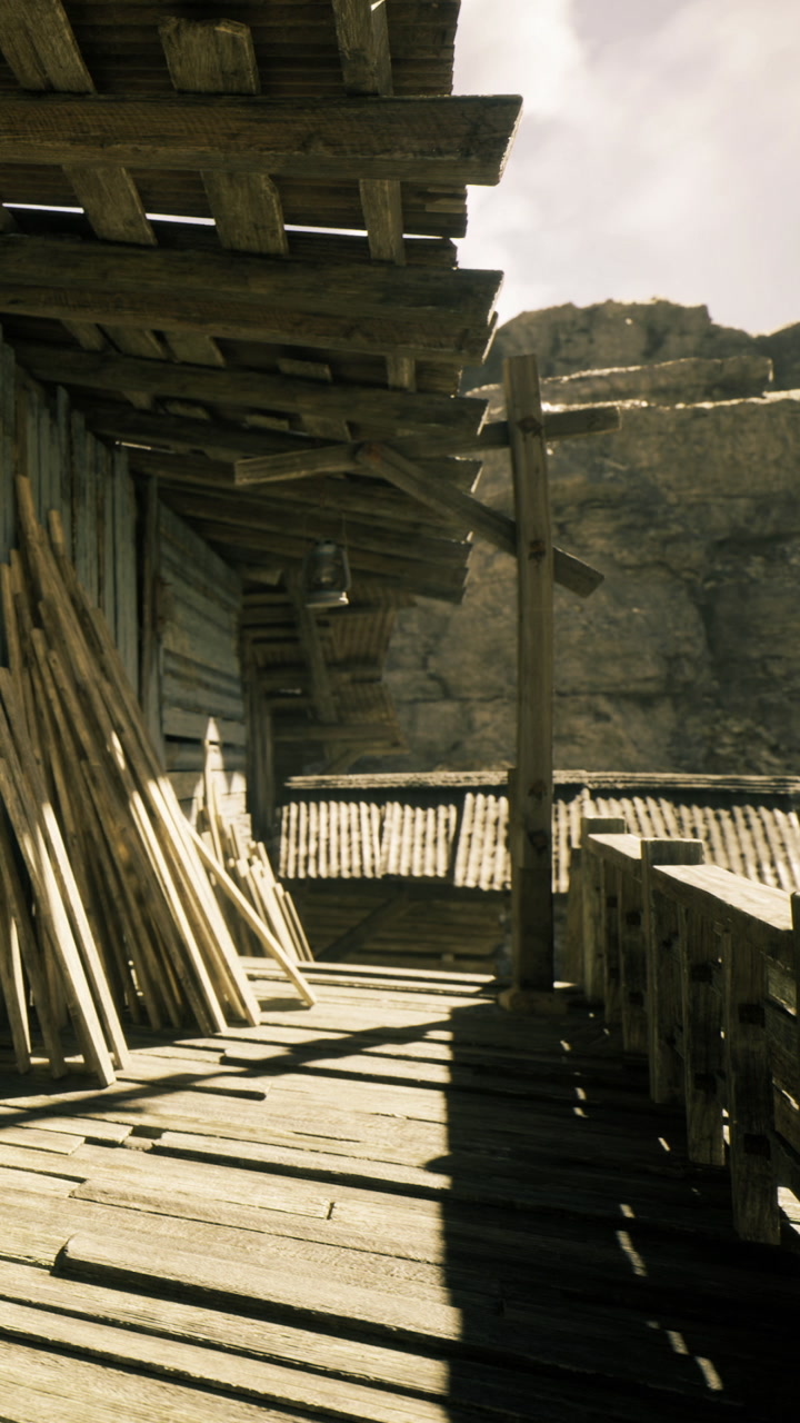 Old wooden deck under the sun near rocky hills with scattered planks leaning
