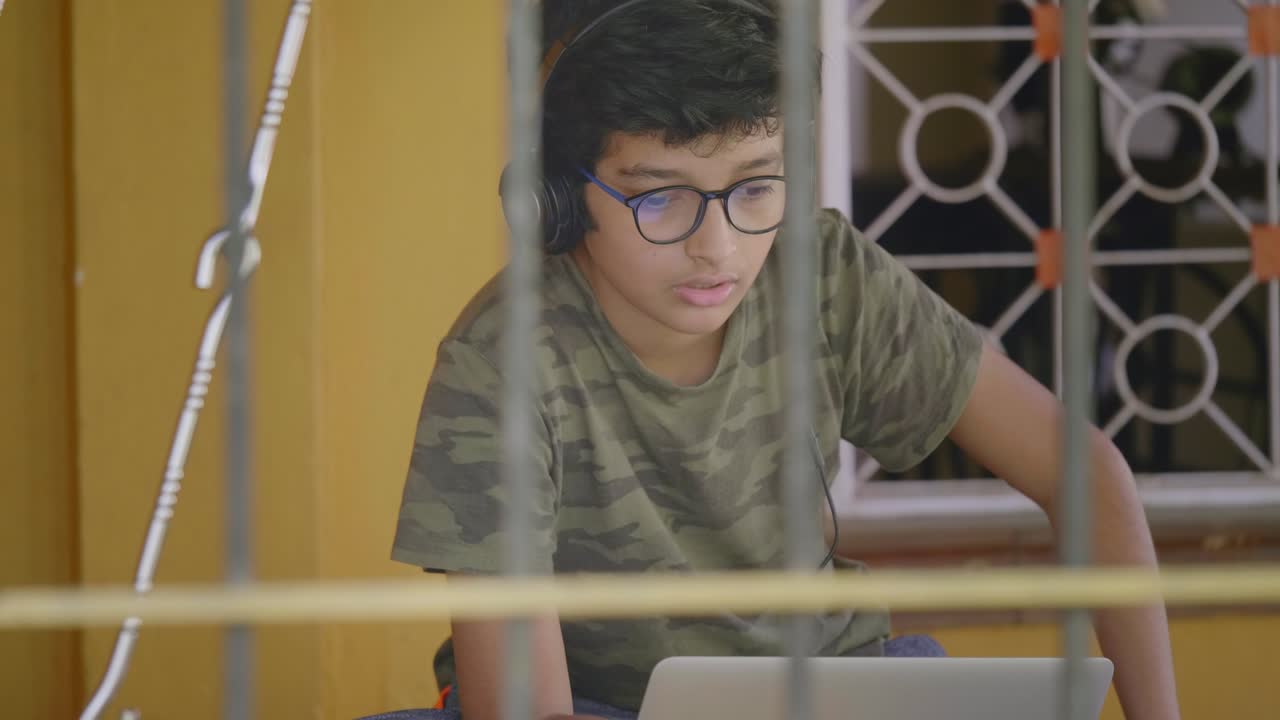 estudiante indio que lee o interactúa durante las clases en línea usando una computadora portátil.