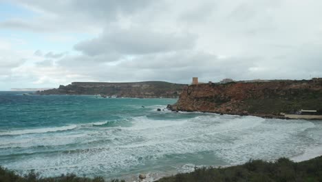 AERIAL:-Huge-Sea-Waves-Rolling-to-Shore-of-Ghajn-Tuffieha-Bay