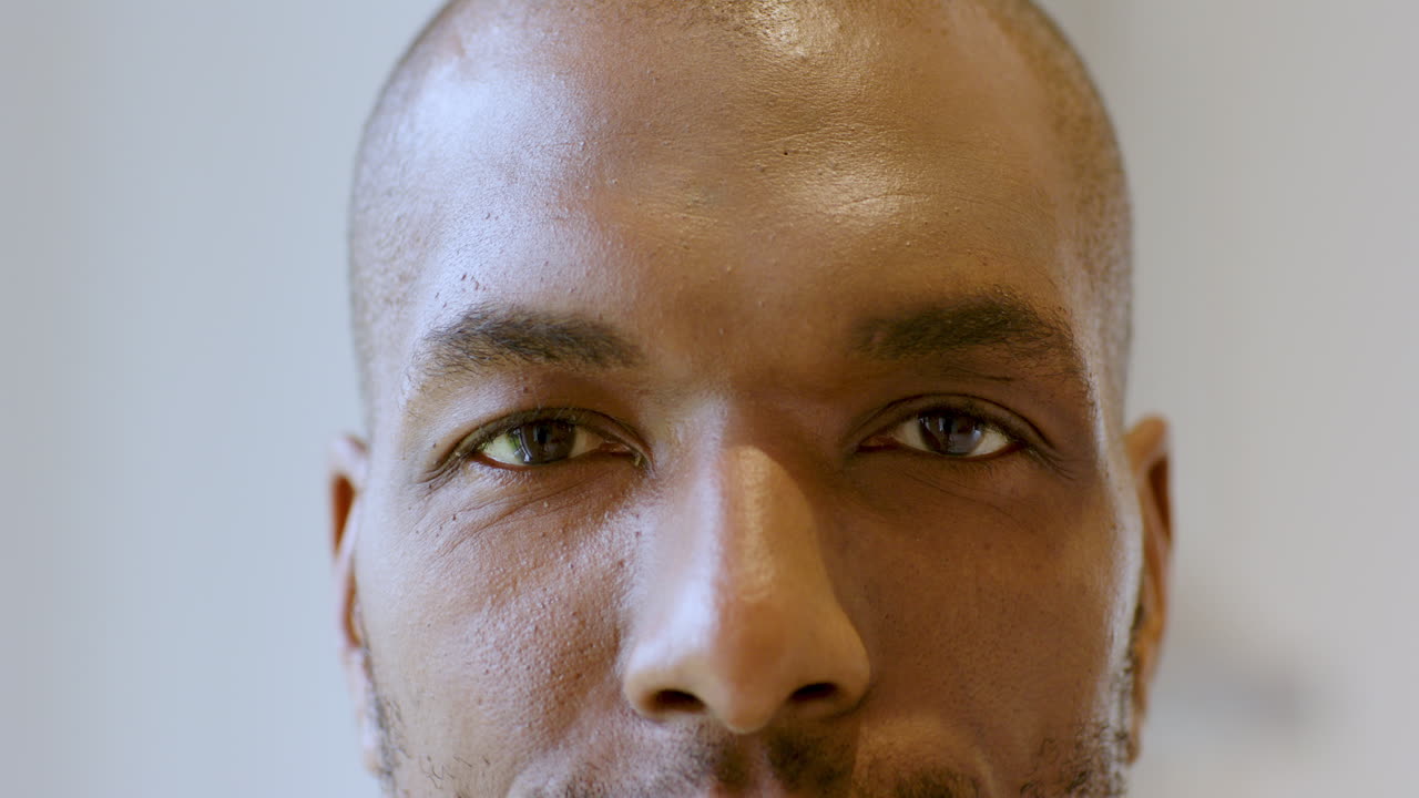 Close-up of man's face with focused expression and natural lighting, at home