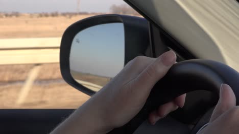 Female-driver-on-road-trip,-woman-holding-steering-wheel-of-a-car,-selective-focus