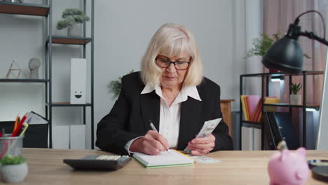 Mujer-De-Oficina-De-Negocios-Senior-Contable-O-Banquero-Usando-Calculadora-Haciendo-Cálculos-De-Dinero-En-Efectivo