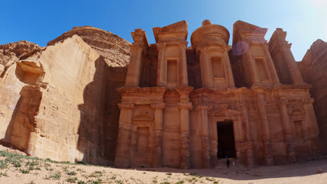 slow pan right shot of tourists at ad deir door, the monastery, petra, jordan