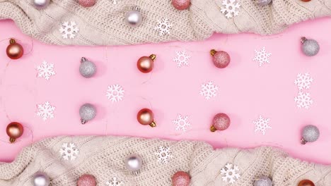 suéter de punto y adornos de navidad y luces aparecen en la parte superior y inferior del tema rosa pastel.