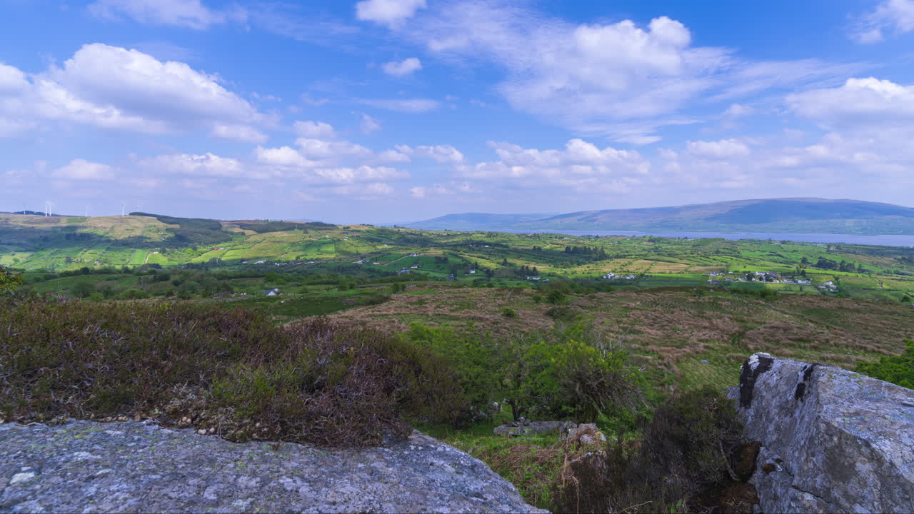 Time lapse of rural landscape with rocky foreground and hills and lake in the distance on a spring sunny day in Arigna mountains in county Leitrim in Ireland