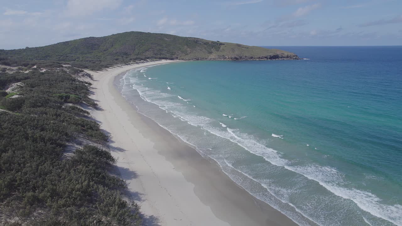 volando sobre la playa de arena blanca con olas de mar turquesa salpicando en verano