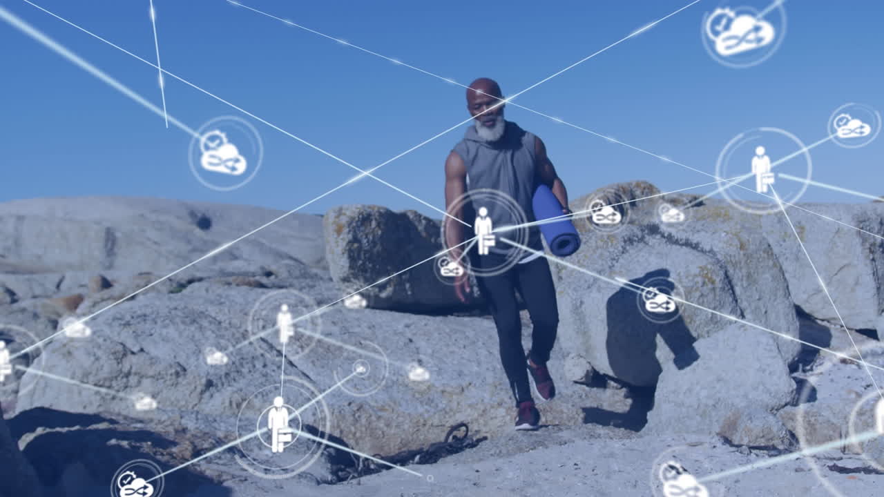 animación de una red de conexiones sobre un hombre afroamericano de edad avanzada con una alfombra de yoga en la playa