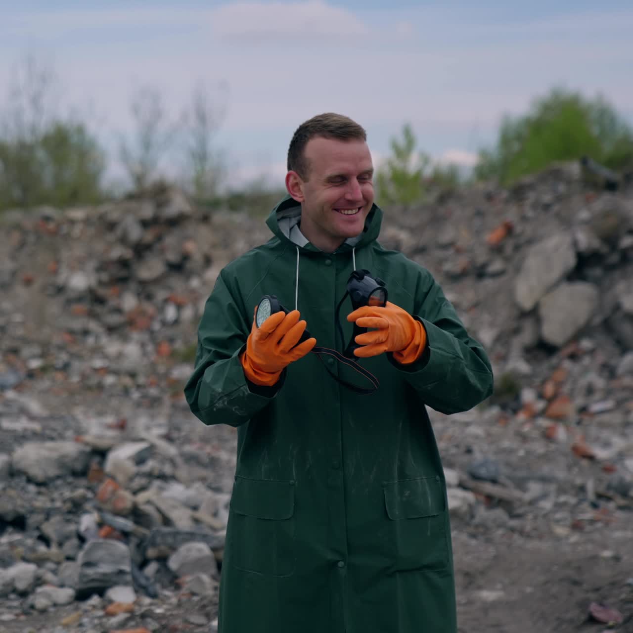 Happy man without gas mask breathe in ruined place. Ecologist in protective suit without respirator satisfied with a normal level of air after the chemical attack outdoors