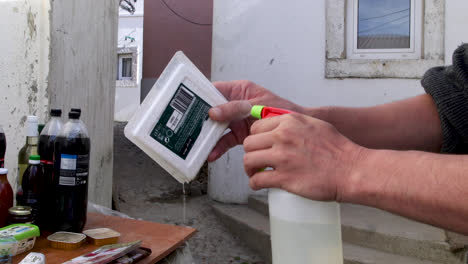 pobre limpia y desinfecta sus compras fuera de su casa en un barrio pobre durante la pandemia de covid-19