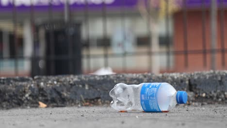 empty plastic bottle thrown on ground on city street