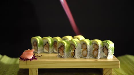 sushi en fondo negro siendo incendiado por llamas