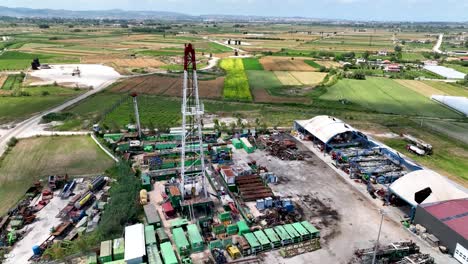 oil rig on industrial site with farming fields nearby