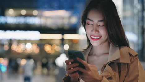 woman using a smartphone at night in a city