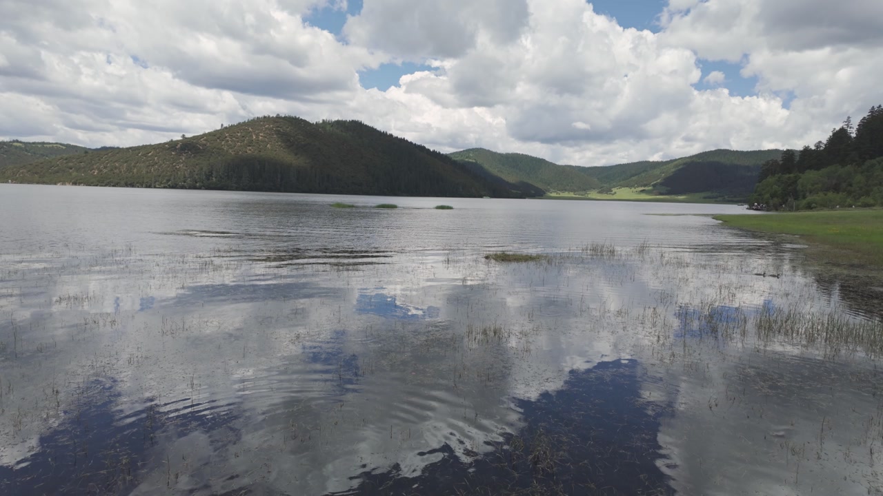 Bita Lake rippling water mirroring clouds, Potatso National Park, Yunnan, China