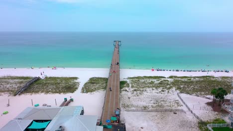 Drohnen-Luftaufnahme,-Die-Den-Pier-Von-Navarre-Beach,-Florida,-Hinunterfliegt-Und-In-Den-Golf-Von-Mexiko-Geht