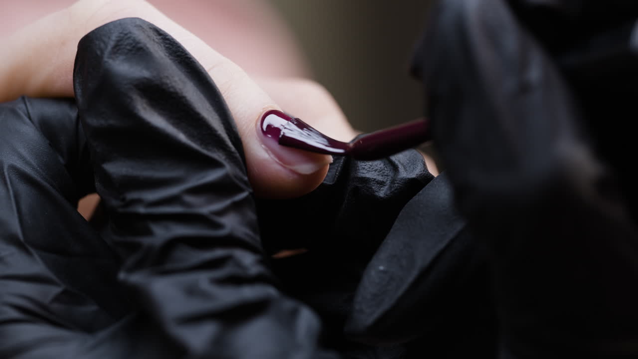 어두운 빨간색 손 라크를 적용합니다.