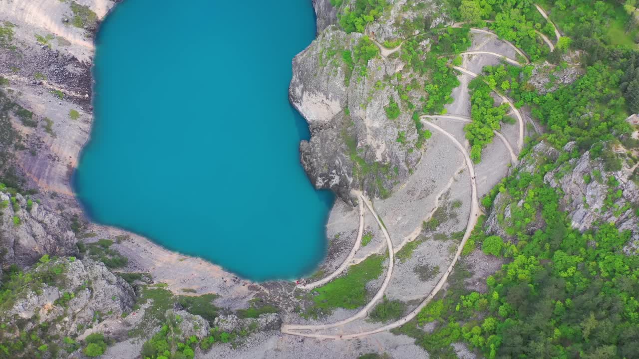 Aerial top down shot of a curvy trail going from Imotski town to Blue Lake in Croatia