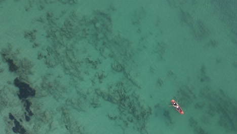 Flyover-of-fisherman-trolling-shallow-green-water-row-boat,-Thailand