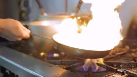 fire in a hot pan in a restaurant's kitchen