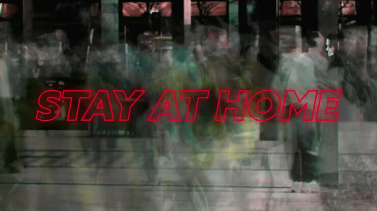 Animation of colourful neon words Stay At Home over people walking on a street