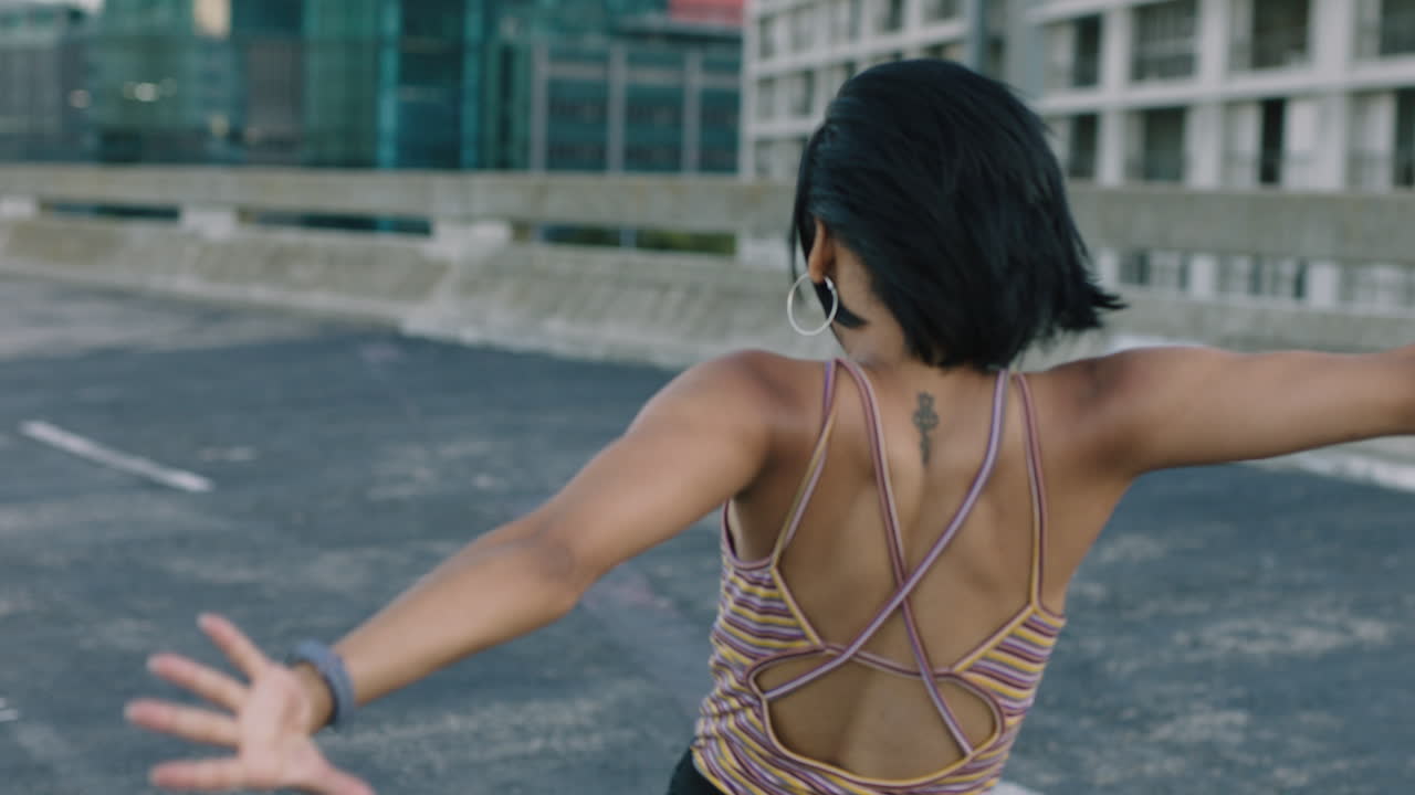 mujer bailarina hermosa joven bailarina hispana realizando baile callejero de estilo urbano en la ciudad practicando movimientos de estilo libre